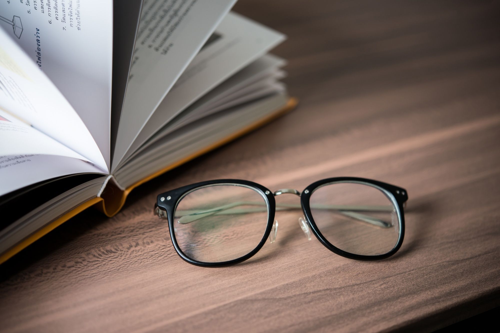 Unas gafas junto a un libro abierto.