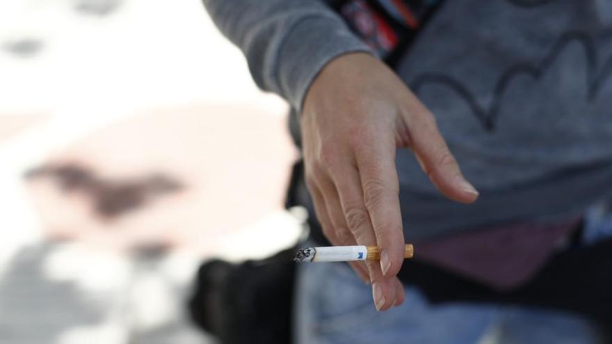 Mujer fumando un cigarro.