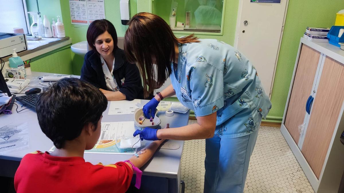 Una sanitaria realiza una prueba para la detección precoz de la diabetes &#039;tipo 1&#039; a un menor.