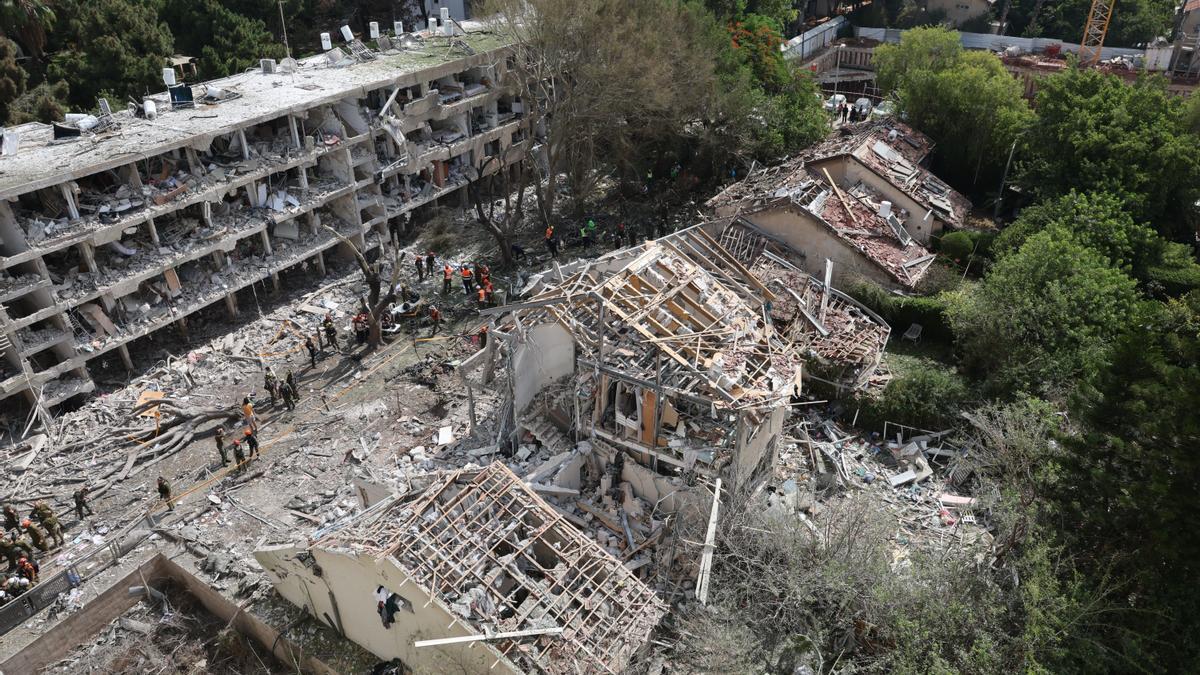 Equipos de rescate y bomberos trabajan tras el impacto de un misil iraní, este domingo en Tel Aviv.