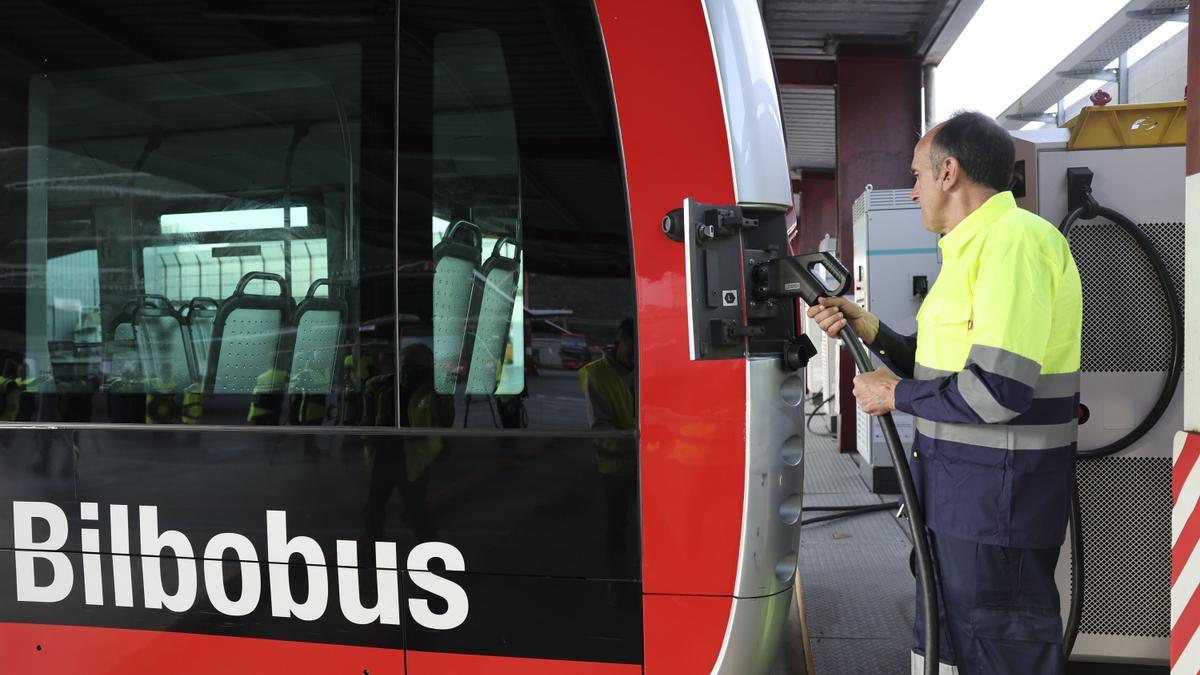 Un trabajador recarga uno de los autobuses eléctricos de Bilbobus en las cocheras de Elorrieta.