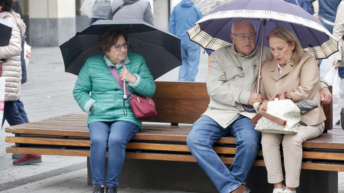 Imagen de archico de varias personas protegiéndose del frío y la lluvia en el centro de Vitoria