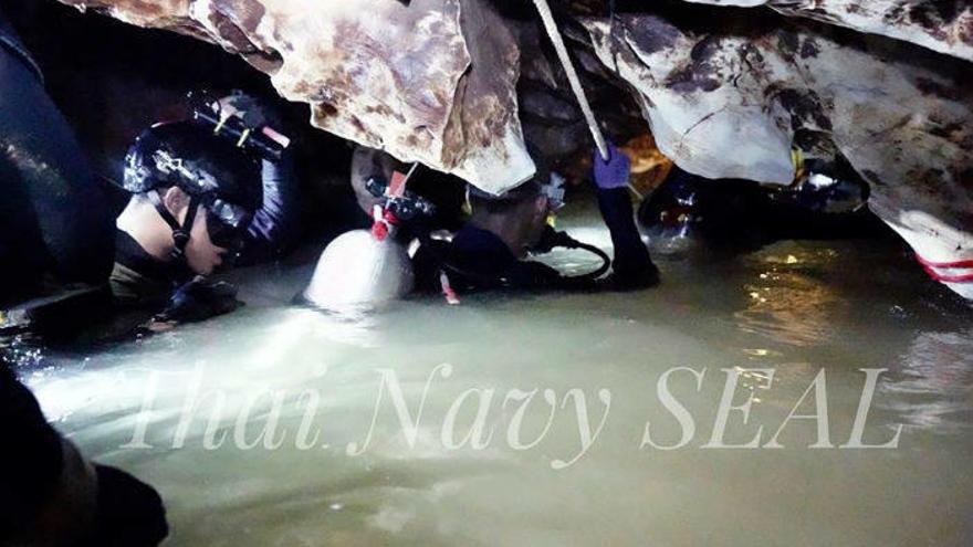 Varios soldados acompañan a los niños atrapados en la cueva tailandesa.