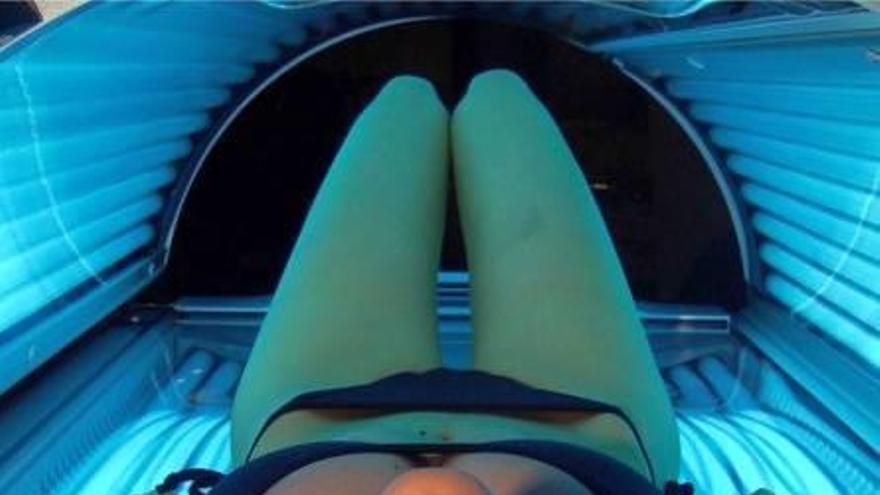 Una mujer se broncea en un solarium
