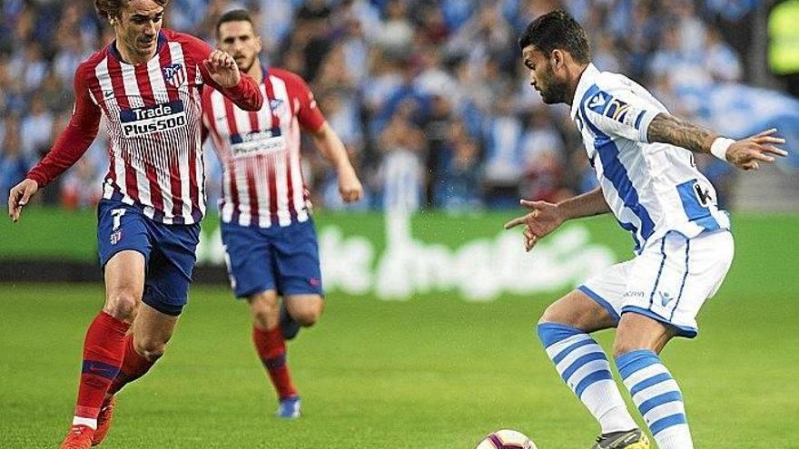 Willian José, que se tuvo que retirar lesionado, trata de zafarse de la presión de Griezmann, que volvió a pisar Anoeta ayer