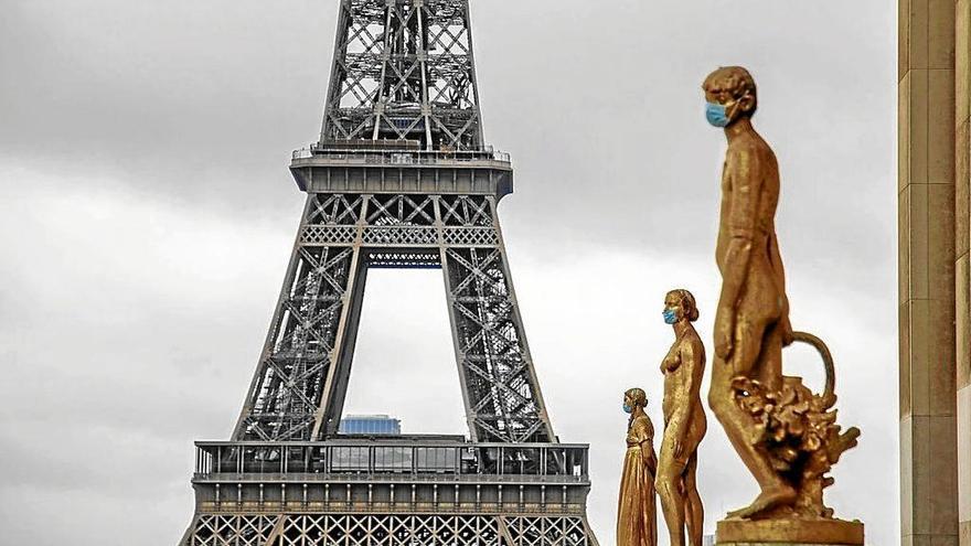 Las estatuas de la parisina plaza de Trocadero, con la Torrel Eiffel de fondo, lucen mascarillas. Foto: Efe