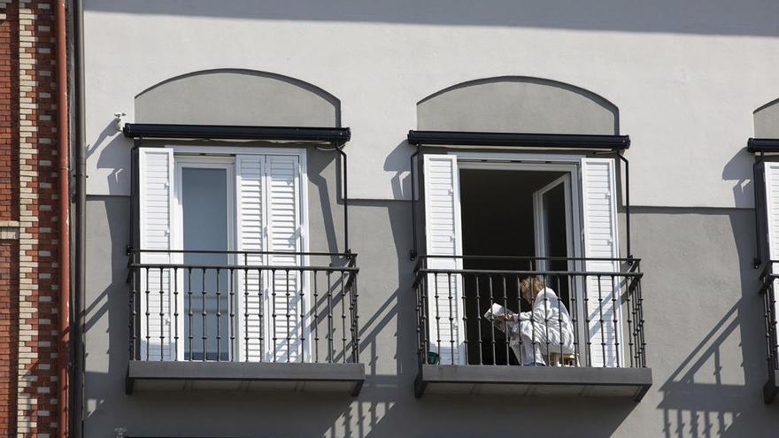 Una vecina lee el periódico en su balcón este domingo en Pamplona.