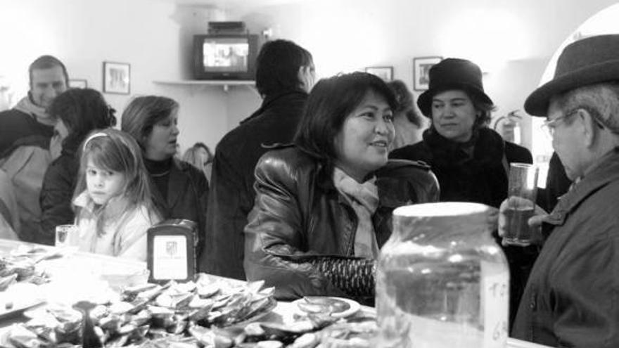 Gente comiendo mejillones en un bar.