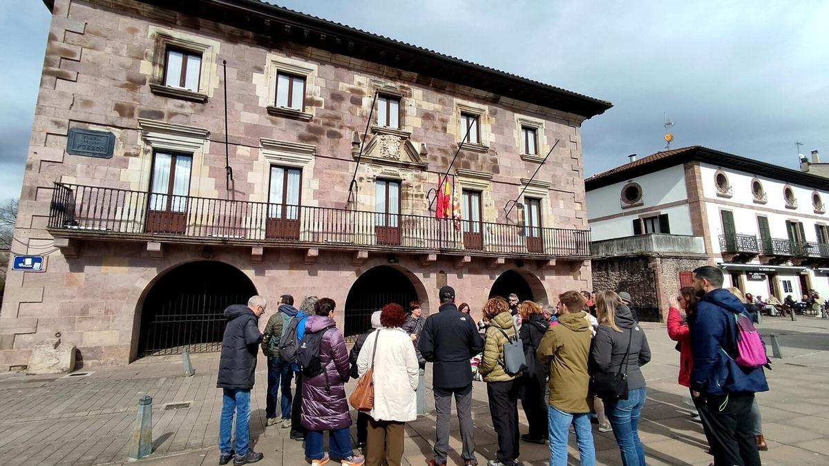 Un grupo de turistas, ante el Ayuntamiento de Baztan durante una visita guiada.