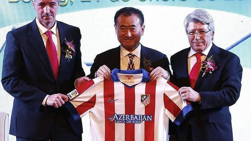 El magnate y propietario del gigantesco conglomerado empresarial Wanda, Wang Jianlin (centro), posa junto al presidente del Atlético de Madrid, Enrique Cerezo (dcha), y el consejero delegado del club rojiblanco, Miguel Ángel Gil