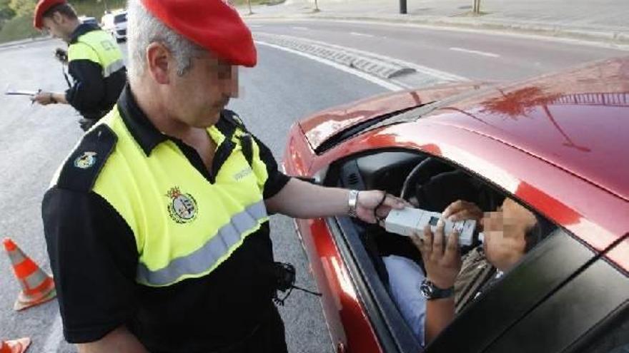 En la imagen, un agente realiza una prueba de alcoholemia a un conductor.