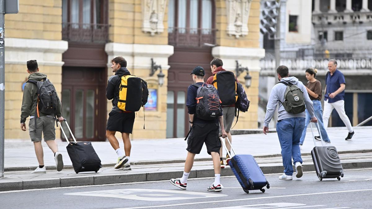 Un grupo de turistas llega con mochilas y maletas para pasar unos días en Bilbao