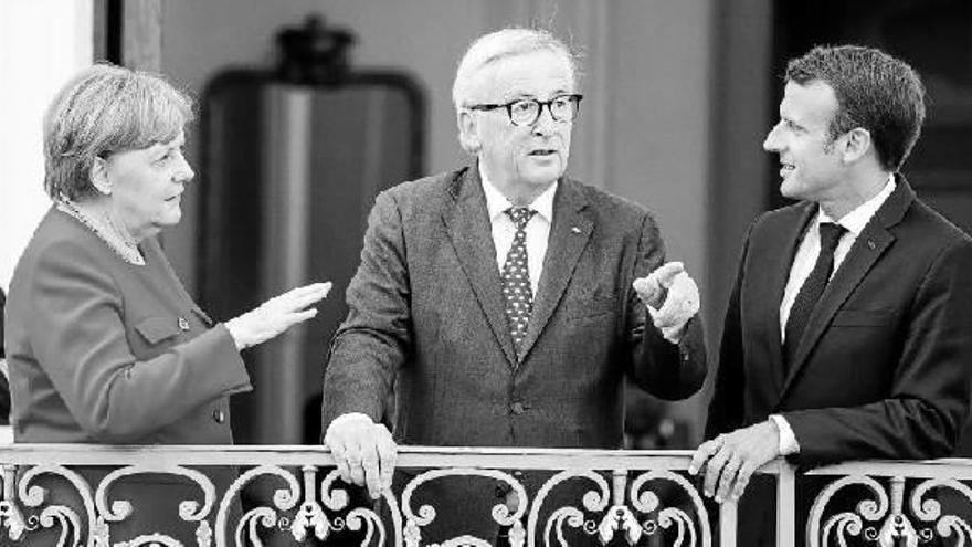 Angela Merkel, Jean-Claude Juncker y Emmanuel Macron, ayer en un balcón del palacio de Meseberg durante la cumbre franco-alemana.