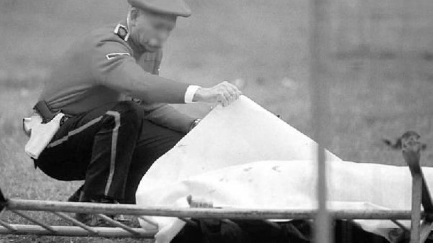 Un agente de la Ertzaintza inspecciona el lugar del atentado en el que un coche bomba acabó con las vidas de Fernando Buesa y Jorge Díez el 22 de febrero de 2000.