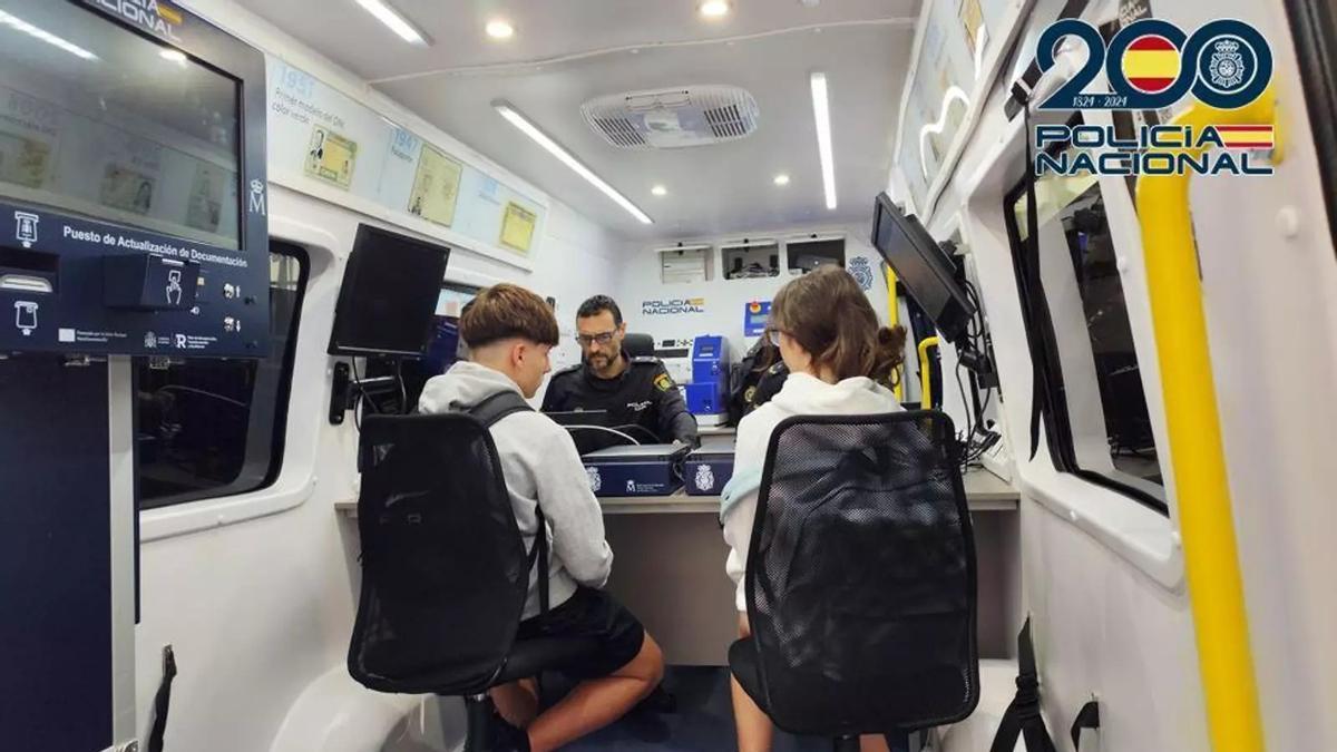 Dos jóvenes tramitando su documentación en un VIDOC de la Policía Nacional