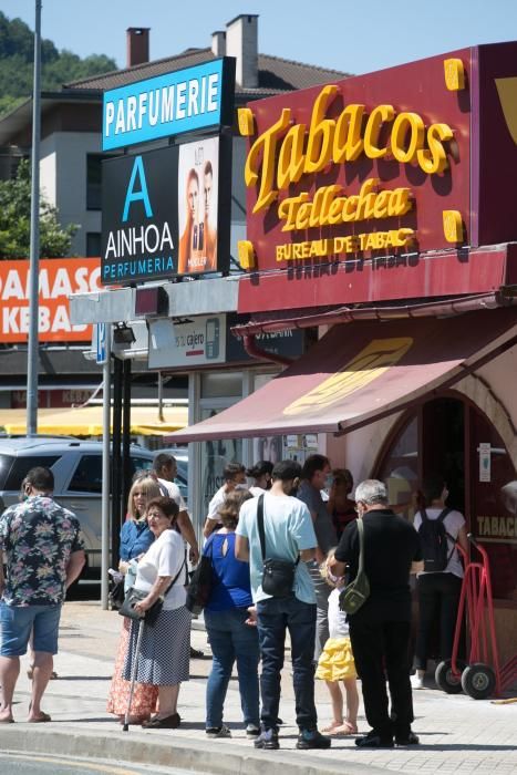 Varias personas hacen cola ante un estanco de Behobia este domingo.