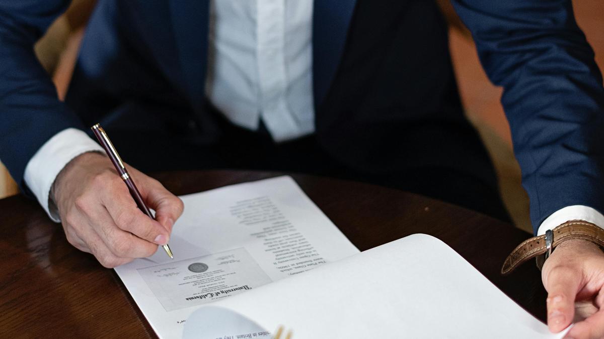Un hombre firmando un contrato.