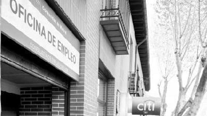 Personas esperando frente a una oficina de empleo.