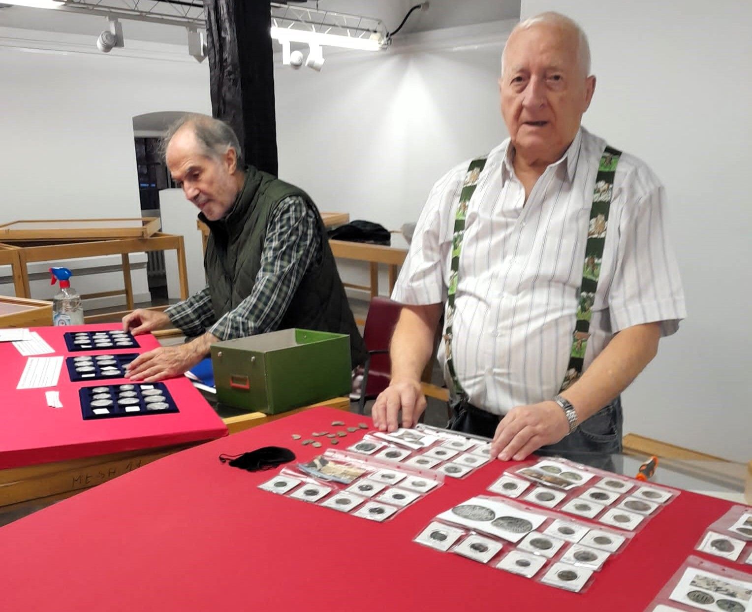 Juan Luis Perello junto a otro compañero de Armuru organizando una de sus colecciones de monedas del mundo antiguo