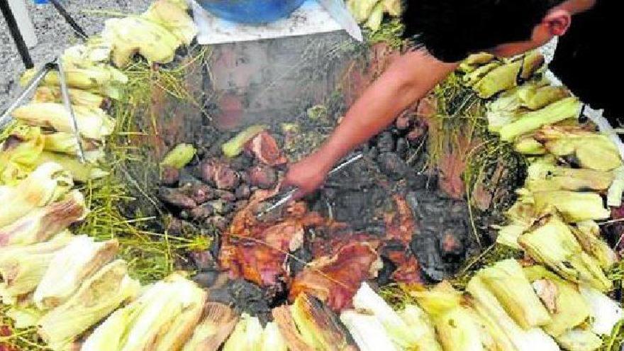 Un hombre andino cocina pachamanca en un tradicional horno bajo tierra.