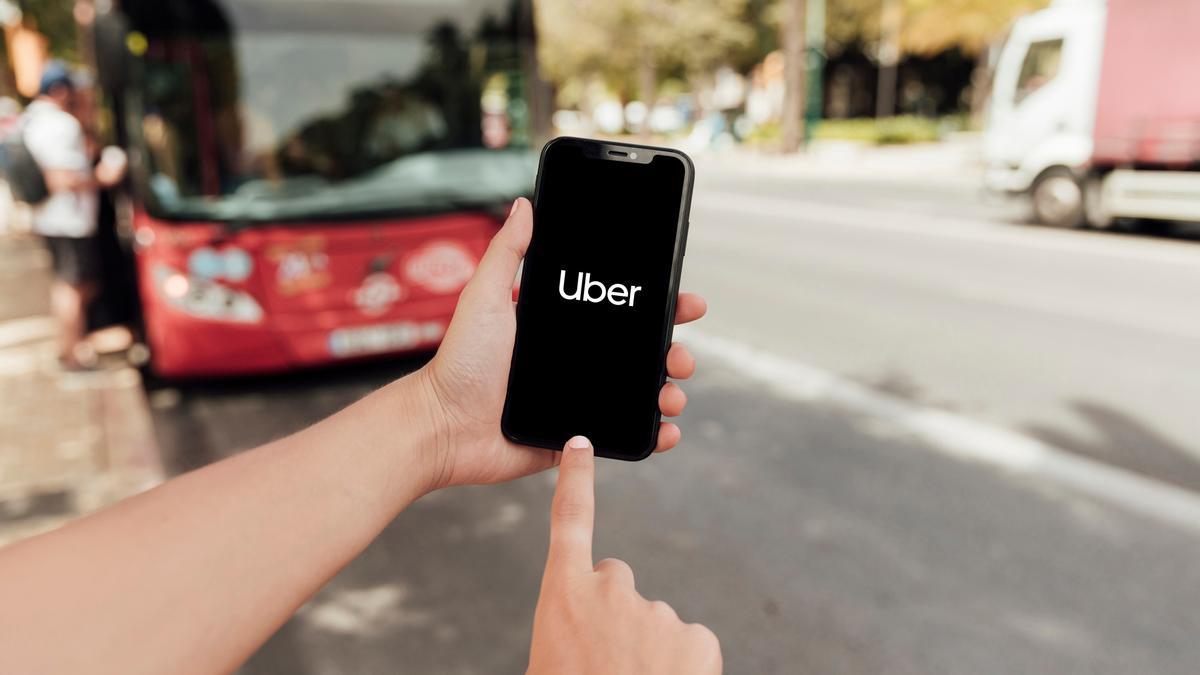 Un cliente se dispone a pedir un coche con conductor a través de una aplicación en el teléfono móvil.