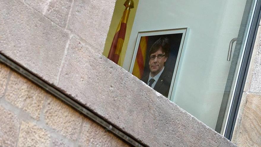 Un cuadro con la imagen de Carles Puigdemont junto a una senyera, ayer en un departamento del Palau de la Generalitat, donde no acudió el president, de viaje a Bélgica.