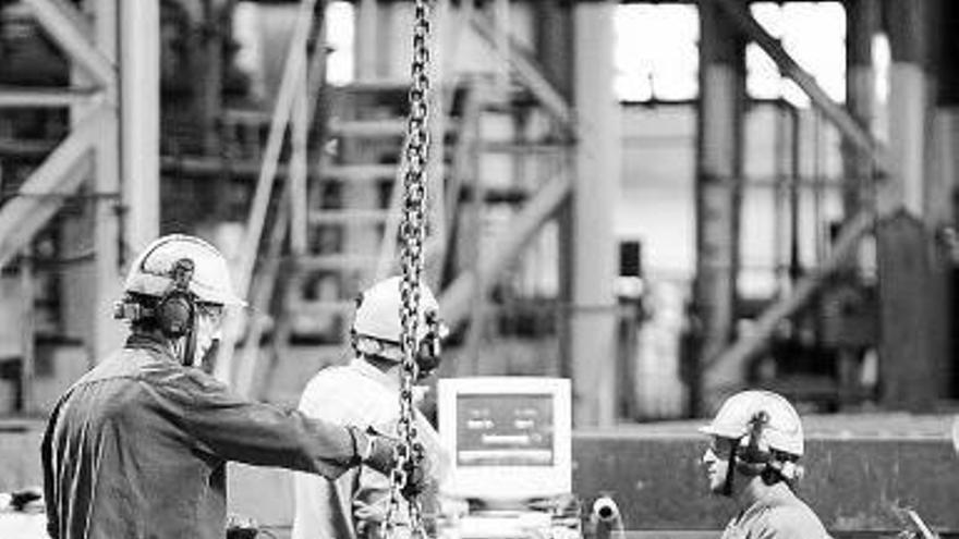 Varios operarios, trabajando en una fábrica.