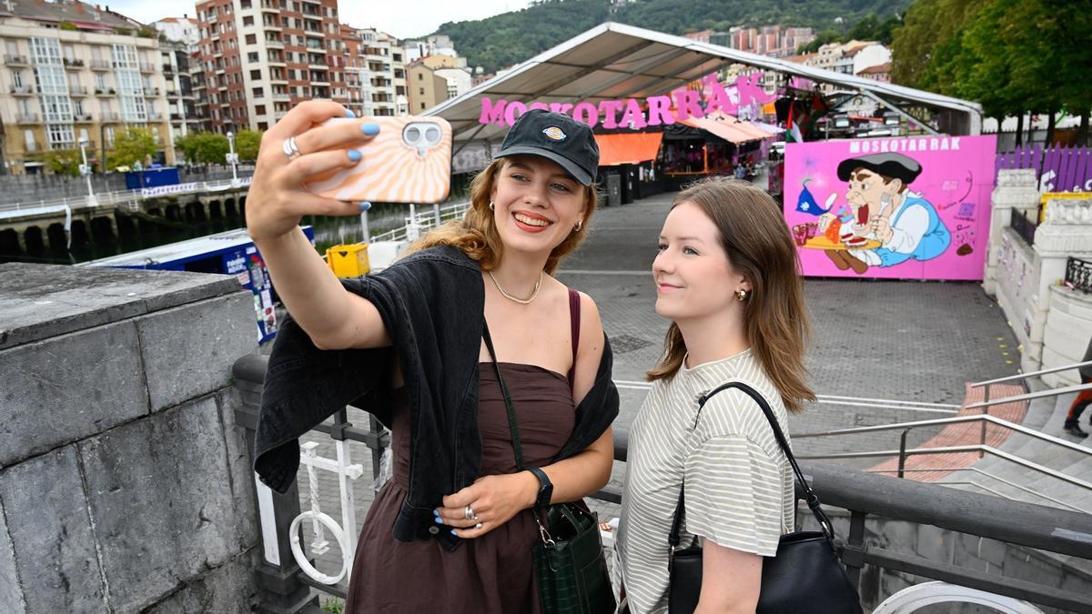 Las amigas lituanas posan frente a las txosnas