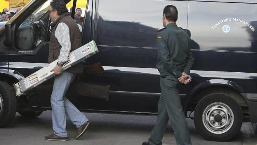 Un agente de paisano porta en una caja la escopeta con la que presuntamente se cometieron los crímenes.