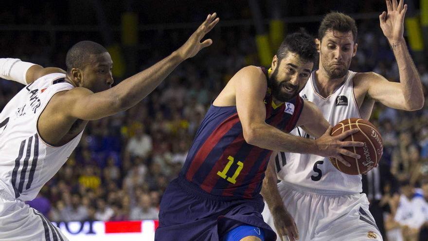El escolta del FC Barcelona, Juan Carlos Navarro (c), intenta superar la defensa del alero del Real Madrid, Rudi Fernández (d), y el pívot estadounidense Marcus Slaughter (i), durante el cuarto partido de la final de la Liga ACB.