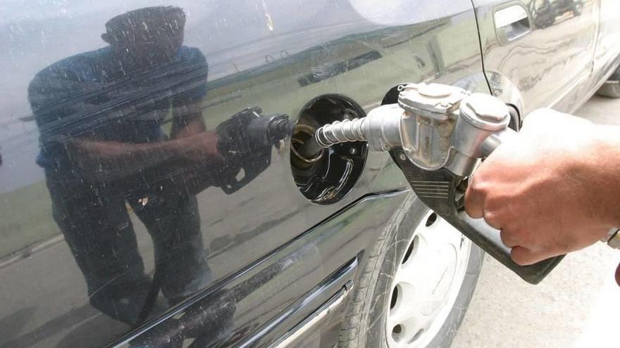 Un hombre se dispone a poner gasolina a su vehículo.
