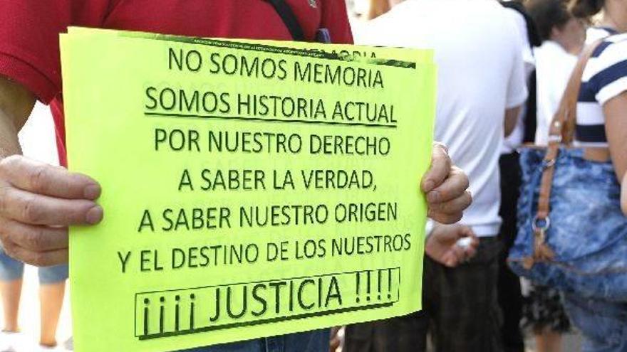 Un manifestante muestra un cartel reivindicativo en una concentración de SOS Bebés Robados.
