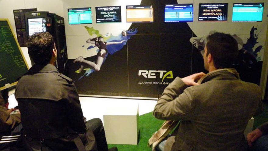 Dos aficionados siguen las competiciones en una casa de apuestas, una opción de ocio que gana adeptos en Navarra.