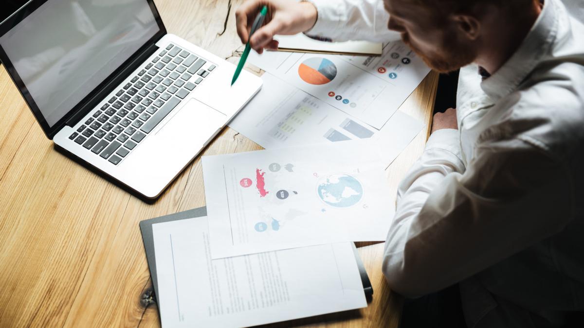 Un empresario analiza documentación en su puesto de trabajo.