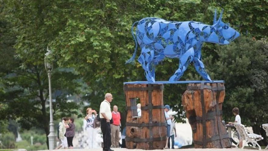 La vaca azul que da la bienvenida a los jardines descansa sobre dos troncos con huecos.