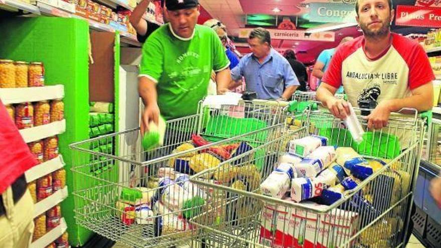Militantes del SAT, en el supermercado de Écija, mientras llenaban los carros de la compra.