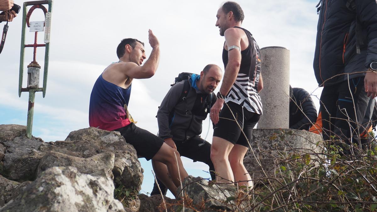 Asier Murua e Iñigo Lariz se saludan junto a vértice geodésico que indica el final del recorrido.