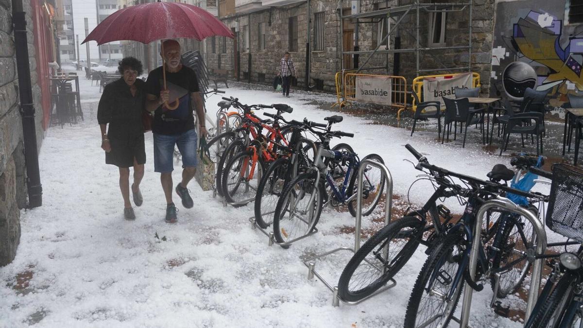 Varias personas pasean por Vitoria tras la fortísima tormenta.