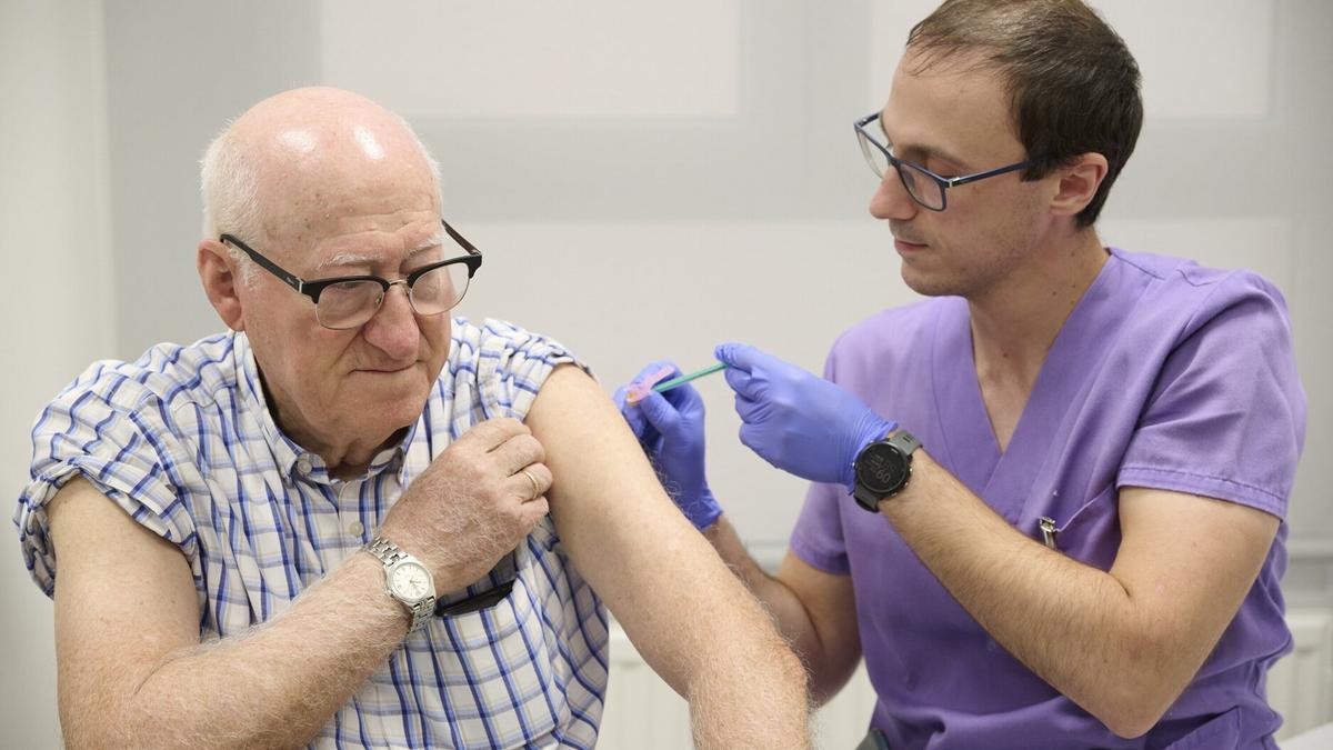 Un enfermero inocula una vacuna contra la gripe a un paciente.