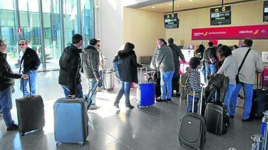 Un grupo de viajeros espera para facturar en el aeropuerto de Noáin