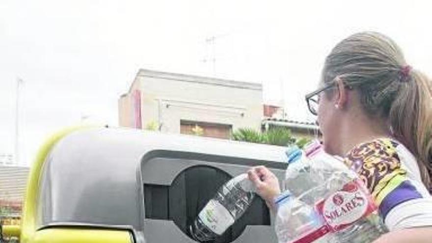 Una mujer, reciclando varios embases de plástico en Tudela.
