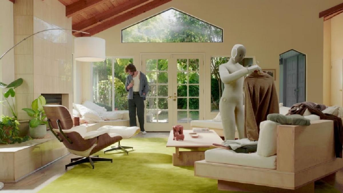 NEO cuelga un abrigo en una percha.