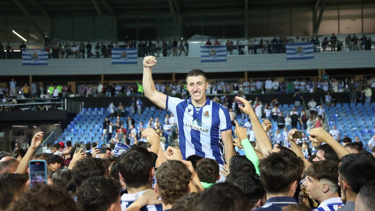 Los jugadores del filial txuri-urdin aúpan a Mariezkurrena, que levanta el puño en señal de victoria.