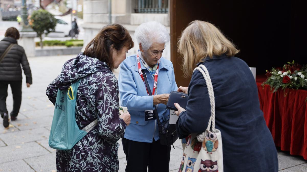 Una voluntaria de Cruz Roja recoge donativos en una de las huchas