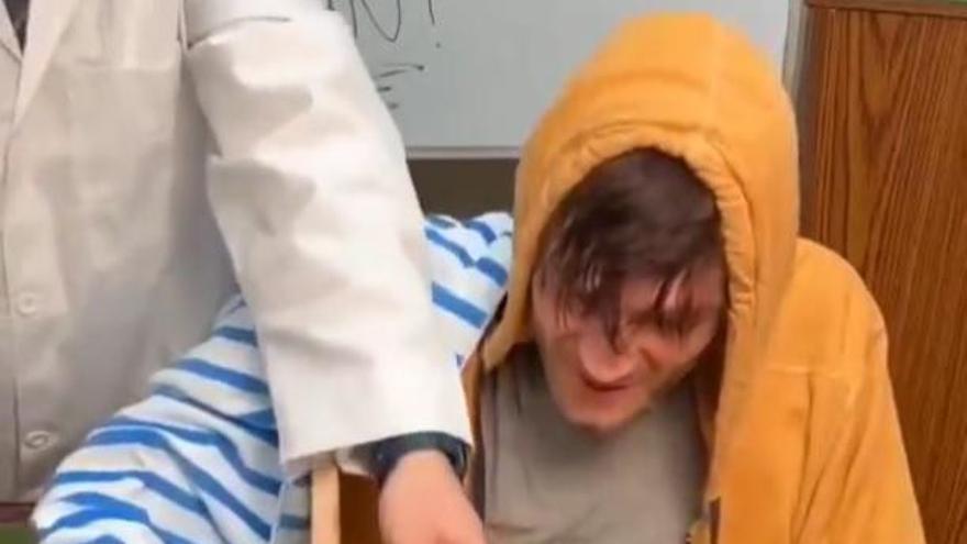 El científico toca con dos reglas la mano verdadera y oculta del joven y la de goma.