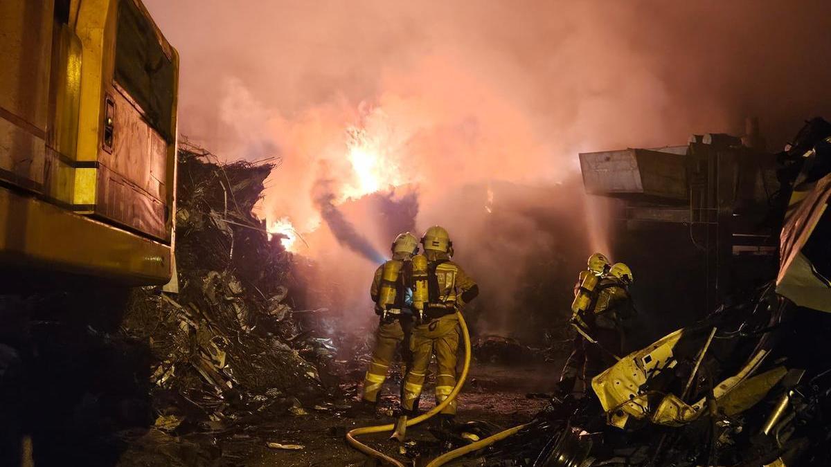 Los bomberos, durante la extinción del incendio declarado en una chatarrería de Irun