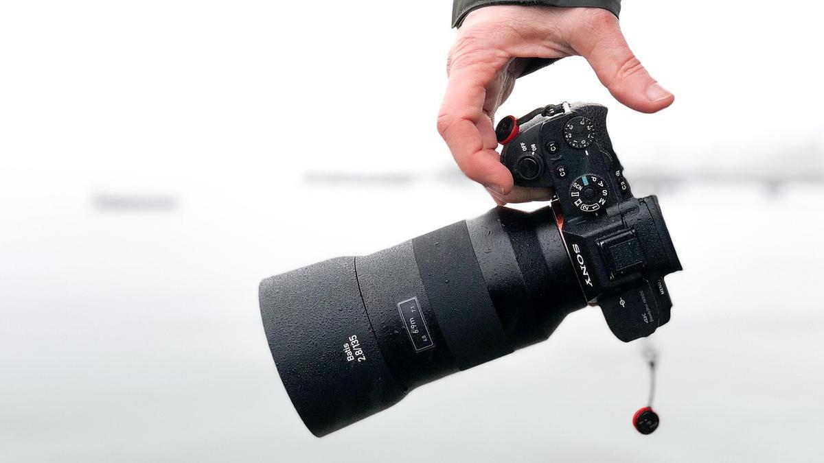 Un hombre sujeta una cámara de fotos.