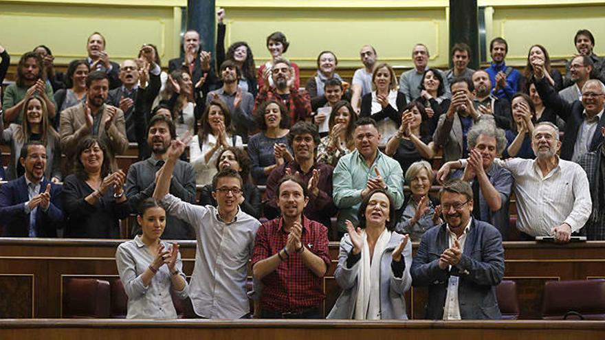 Los diputados del Grupo parlamentario de Podemos aplauden en sus escaños al finalizar hoy en el Congreso el último pleno de la XI Legislatura