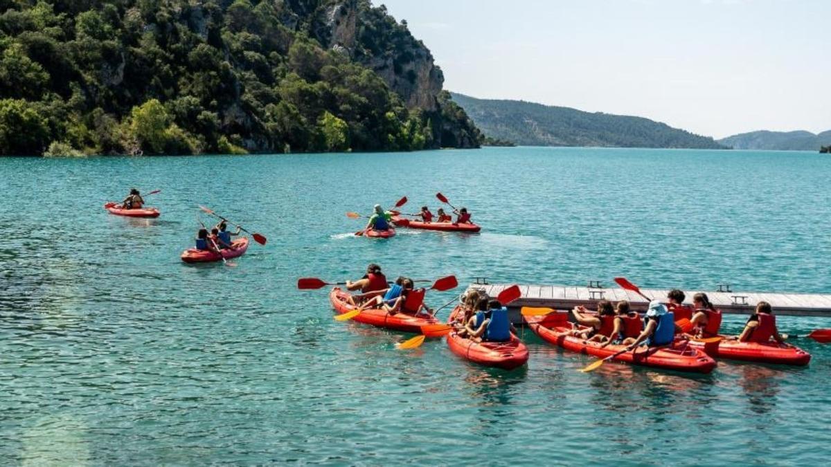 Un grupo de chavales  y sus monitores montan en canoa en un campamento de verano.