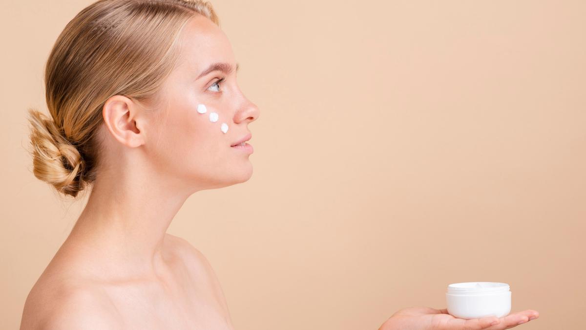 Mujer se aplica crema en el rostro